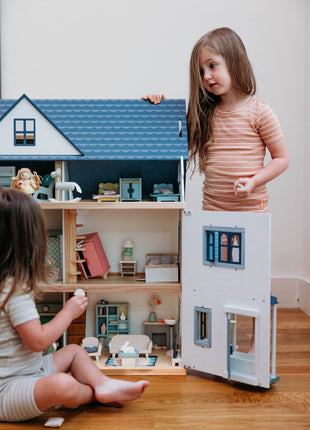 Children playing with the Tender Leaf Dovetail House wooden dolls house